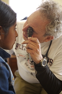 A volunteer doctor examines a patient