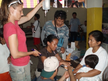 Patty Webster (left), founder of Amazon Promise, helps physician assistant Veda Wong Sing (center) and Dr. Javier Villanes (back) treat a dehydrated boy in Belèn, Loreto Province, Peru.